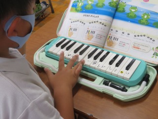 かえるのがっしょうの鍵盤ハーモニカでの指の動かし方を練習する２年２組の子ども