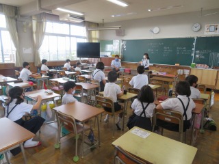 町別児童会で登校の様子を反省したり，夏休みのくらしに好いて話を聞いたりする子供たち