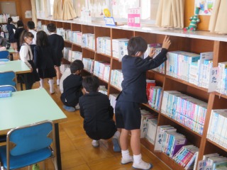 図書館で本を借りる２年１組の子どもたち