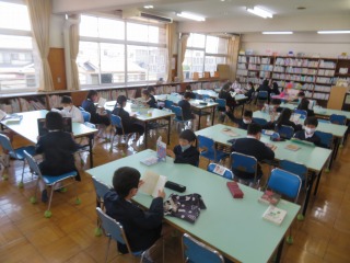 図書館で本を借りて読んでいる４年１組の子どもたち