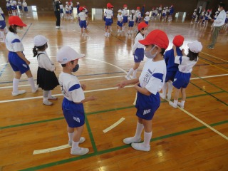 自己紹介とじゃんけん肩たたきをする２年生と４年生の子どもたち