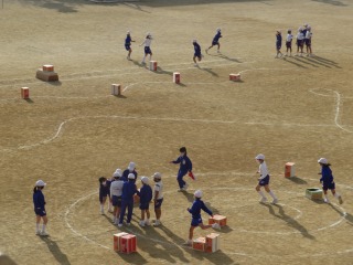 ダンボールや跳び箱を跳び越す３年２組の子どもたち