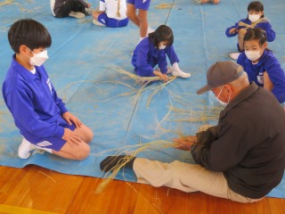 お飾りづくりを教えてくださる学校支援ボランティアと子どもたち