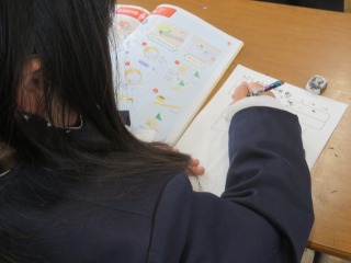 動くもちゃ計画を書く２年２組の子ども