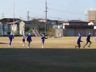 寒い中，縄跳びをしながらトラックを走る５年２組の子どもたち