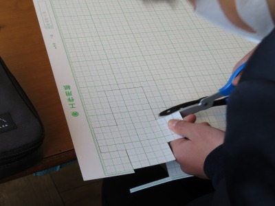工作用紙で直方体の展開図をつくる４年１組の子ども